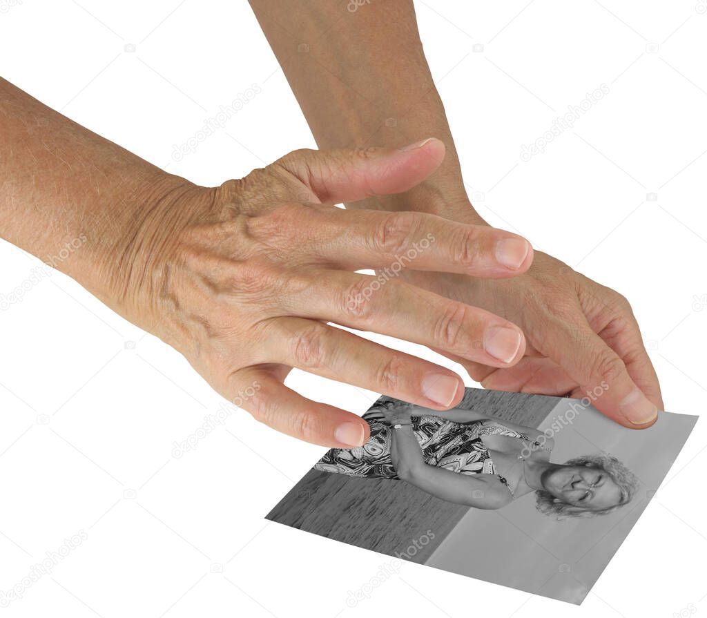 Sending distant healing to woman via photograph - holding a black and white photo of a middle-aged female in one hand with the other hand hovering above channelling healing energy on white background