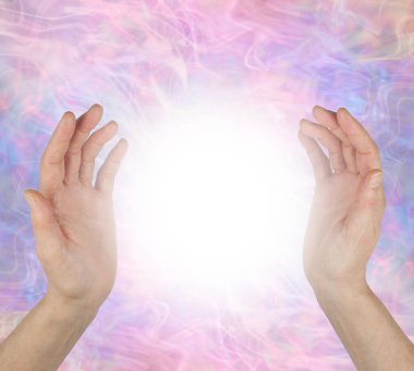 Ellerin arasındaki ruhani iyileşme enerji alanını algılıyor. Kadın elleri 25 cm aralıklarla açık pembe bir mor enerji alanı arkaplanına karşı parlak beyaz bir ışık küre enerjisiyle karşı karşıya. 