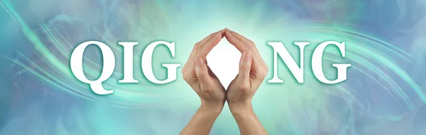 Qigong healing hands concept banner - female hands making the O of QIGONG against a jade green energy formation background with white light behind the hands and copy space