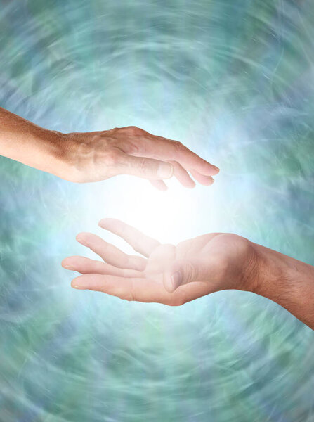 Male and Female sensing energy field  - male hand opposite female hand with a white light orb in between against a jade green rotating energy field background with copy space