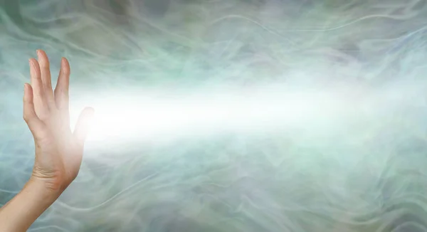 Female Pranic healer sending focused energy from right hand palm chakra - upright open hand facing out with a stream of white energy flowing horizontally against a pastel green energy field background with copy space — Stock Image Female Pranic Healer Sending Focused Energy Right Hand Palm Chakra Stock Image