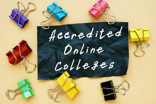 Educational concept about Accredited Online Colleges with sign on the piece of paper.