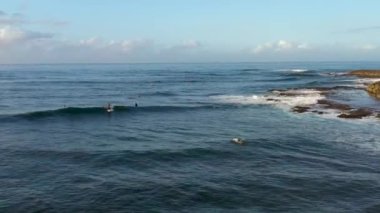 Hawaii 'nin kuzey kıyısında sörf yapan bir sörfçü.