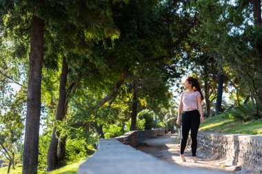 Güzel beyaz bir kadın parkta spor yapıyor.