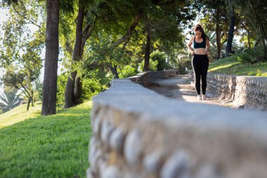 Güzel beyaz bir kadın parkta spor yapıyor.