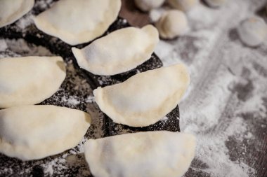 Çiğ hamur köftesi, patates ve soğanlı koyu ahşap masa Varenyky.