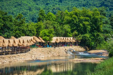 Krak-e-dok çalışan aşağı nehir boyunca barakalarda bambu yapılmış