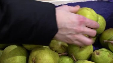 İnsan süpermarkette armut seçer.