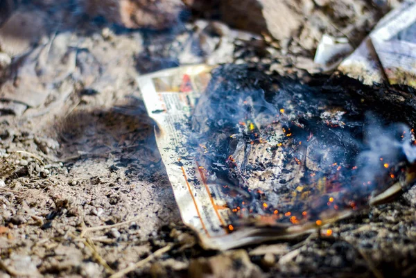 burning newspaper on the ground