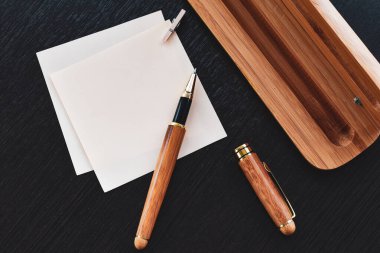 Masanın üzerinde kalem olan bir kağıt parçası.