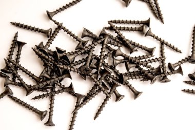 Beyaz arka planda dağınık vidalar