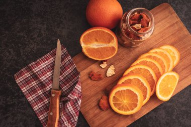Kesme tahtasında dilimlenmiş portakal.