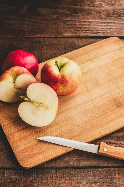  четыре свежих яблока для приготовления на разделочной доске
