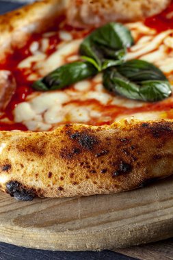 İtalyan pizzasını ahşap bir masanın üzerinde doğrama tahtasıyla kapat.