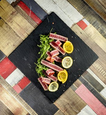 Kızarmış ton balığı, pembe tuz ve roket salatası.