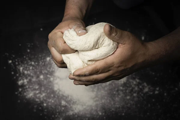 Siyah arka planda el yapımı pizza.