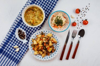 Beyaz masadaki üç tabaktan oluşan yemek takımı.. 