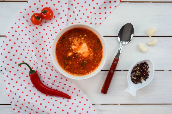 Вкусный томатный суп со сметаной на обед на белом деревянном столе . — стоковое фото
