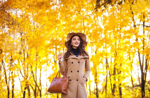 Modische Frau mit breitkrempigem Hut im Herbst draußen. Gelber Bokeh-Hintergrund — Stockfoto
