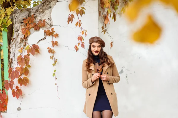 Entzückendes stilvolles Mädchen in beigem Mantel und Lederbarett im Herbst im Freien — Stockfoto