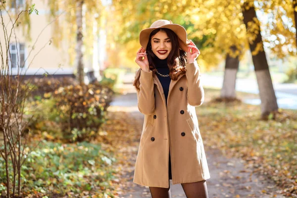 Modische Frau mit breitkrempigem Hut verbringt ihre Freizeit im Herbst draußen. — Stockfoto