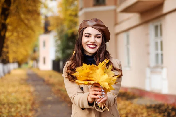 Schöne modische Frau verbringt im Herbst Zeit im Freien. Gelbe Blätter. — Stockfoto