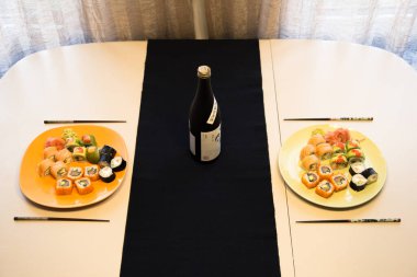 Bir kaç kahverengi porselen ve bir beyaz kupa ön planda yakın plan ile kancalara asılı ve arka plan sıcak bej renklerle bulanık..