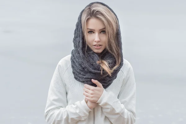 Menina bonita com lábios bonitos em uma jaqueta branca com um lenço quente na cabeça no tempo frio Imagem De Stock