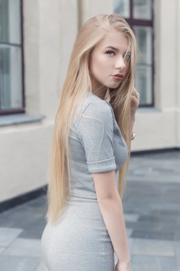 nazik portre dolgun dudaklar ve mavi gözlü bir gri takım elbiseli, uzun sarı saçlı güzel bir şirin kız bak kameraya