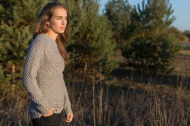 gözleri iri ve gün batımında ormanda yürüyüş bir sıcak kazaklı geniş gür kaşları ile güzel yalnız genç kız