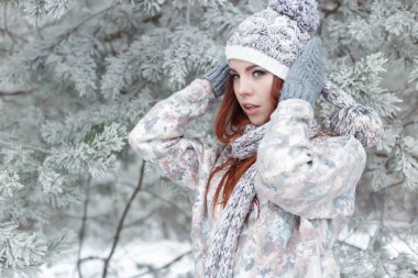 güzel neşeli şirin Kızıl saçlı kız bir kap ve eşarp güzel orman peri karda oynuyor