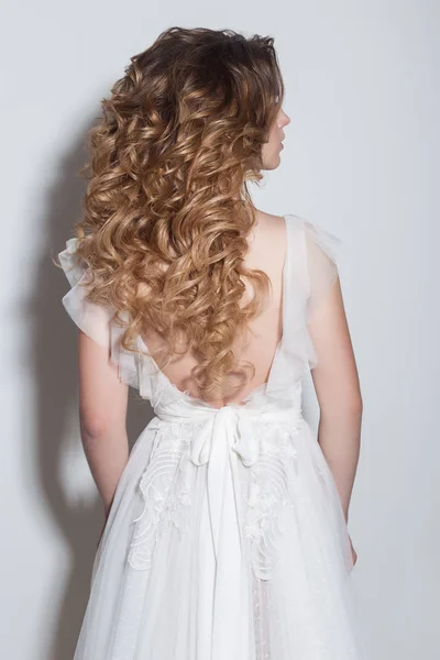 Красиві модні зачіски для молодих дівчат красива ніжна наречена в красивій весільній сукні на білому тлі в студії — стокове фото