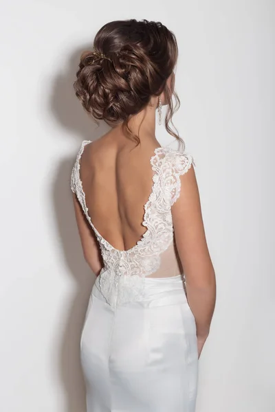 Belle acconciature alla moda per le giovani ragazze bella sposa delicata in un bellissimo abito da sposa su uno sfondo bianco in studio — Foto Stock