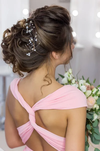 Belo penteado elegante noite no cabelo escuro menina bonita com um ornamento de pedras em seu cabelo, penteado para o casamento — Fotografia de Stock