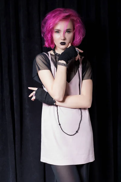 Модний знімок дівчини з рожевим волоссям в рожевій сукні на чорному тлі в студії, дівчина-хіпстер, молодіжна мода — стокове фото