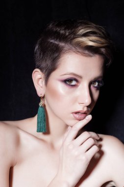güzel sexy şehvetli genç kız çıplak, güzel bir akşam takı küpe, kolye, parlak makyaj ile kısa saçlı bilezik moda stüdyoda siyah bir zemin üzerine ateş