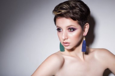 güzel sexy şehvetli genç kız çıplak, güzel bir akşam takı küpe, kolye, parlak makyaj ile kısa saçlı bilezik moda stüdyoda siyah bir zemin üzerine ateş