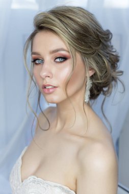 nazik makyajlı bir güzel saç modeli şenlikli parlak küpe ile düğün elbise ve bir yüzükle süs saçında bir güzel şirin mutlu gelin portresi