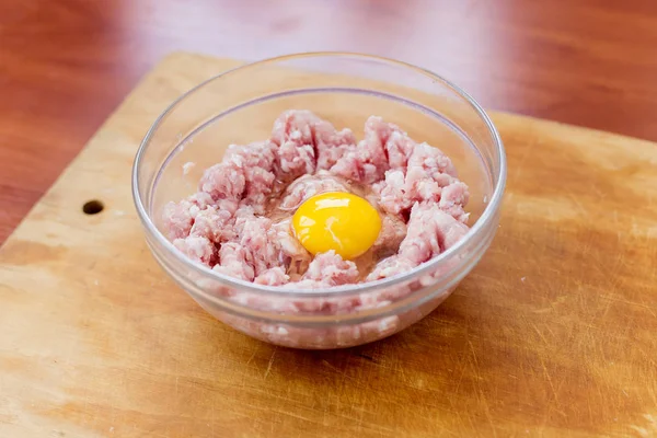 Picadillo fresco cocido para el plato con huevo crudo yacen en un plato — Foto de Stock