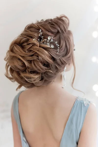 穏やかな青い光で花嫁の美しいボリューム髪型ドレス大きなイヤリングや髪の装飾品 — ストック写真