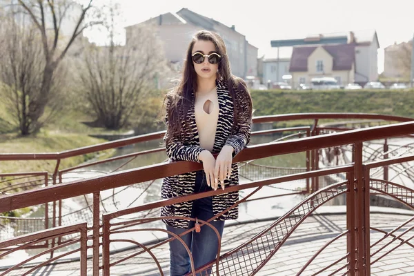 Beautiful sexy girl with long dark hair in sunglasses walking around the sunny city — Stock Photo, Image