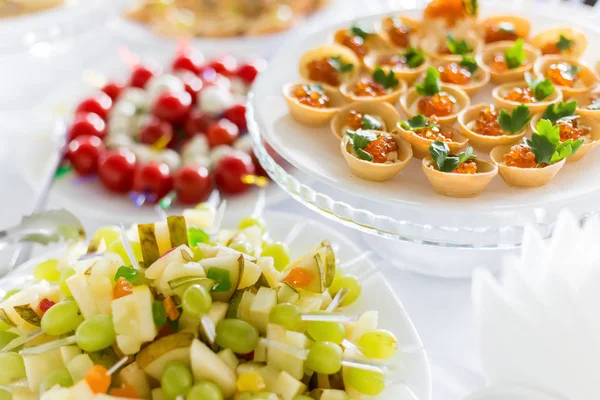 A small table with a delicious buffet of canapes, caviar, sandwiches