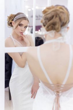 Güzel sevimli ihale genç kız gelin gelinlik içinde akşam saç ve hafif hafif makyaj aynaları