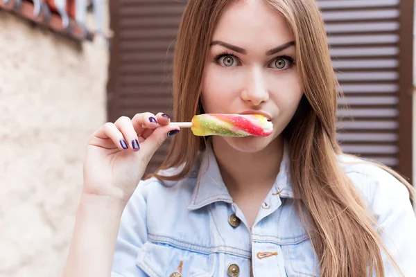 Schöne fröhliche sexy süße rothaarige Mädchen essen farbiges Eis auf den Straßen der Stadt — Stockfoto