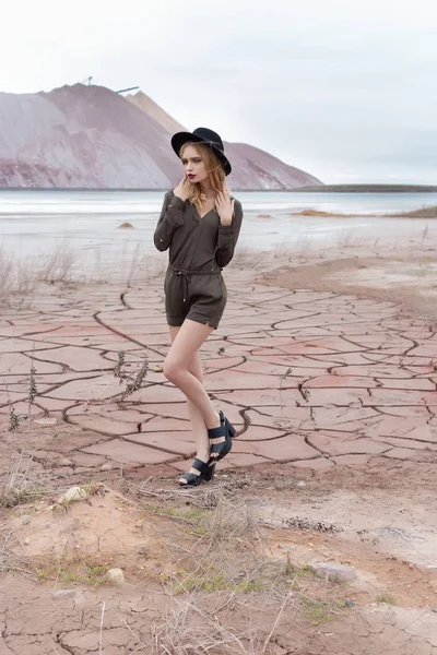 Belle fille mince sexy dans un chapeau noir dans les montagnes avec un vent fort — Photo