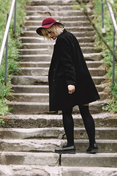 Kırmızı şapka ve siyah ceket şehirde yürüyüş güzel şirin kız