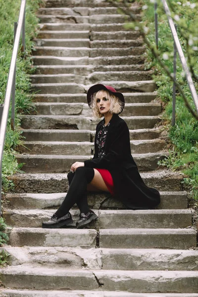 Kırmızı şapka ve siyah ceket şehirde yürüyüş güzel şirin kız