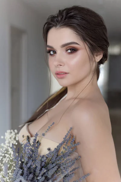 Bela menina morena sexy em vestido elegante com trem longo com flores de lavanda — Fotografia de Stock