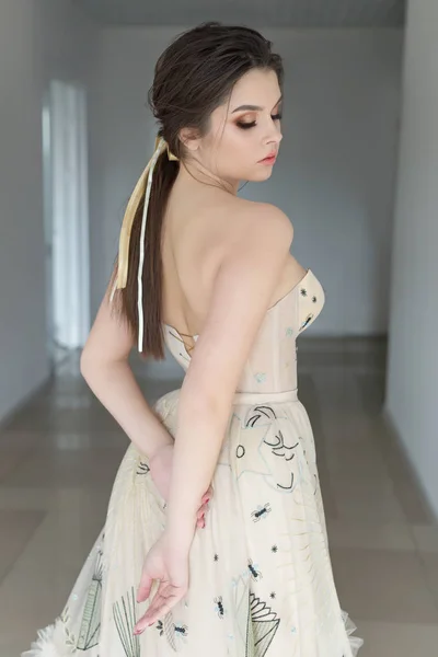 Vacker sexig brunett tjej i elegant klänning med långa tåg med lavendelblommor — Stockfoto