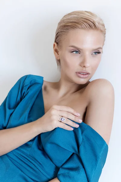 Linda menina linda com olhos azuis em um vestido azul em um fundo branco no estúdio — Fotografia de Stock